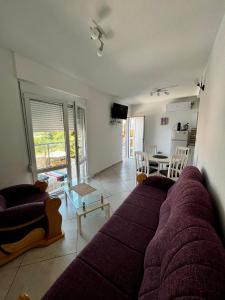 a living room with a purple couch and a table at Apartments Apartmani Bojana in Utjeha