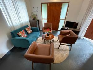 a living room with couches and chairs and a table at Cheerful 2-Bedroom Villa with Private Plunge Pool, Candolim, Goa in Marmagao