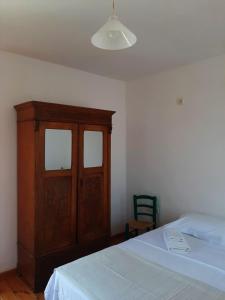 a bedroom with a bed and a wooden cabinet at The Garden in Chios