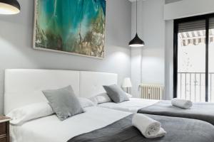a bedroom with two beds and a painting on the wall at City Center in Granada