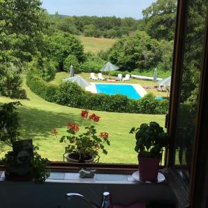 una finestra con vista sulla piscina di Les Marronniers Gîtes a Crozant