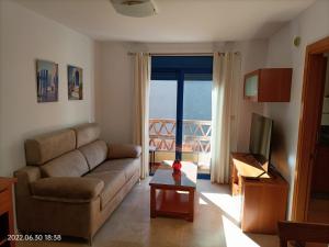 ein Wohnzimmer mit einem Sofa und einem TV in der Unterkunft Apartamento Puerto - Sol. in Fuengirola