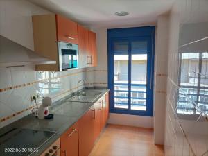 eine Küche mit Holzschränken und einer blauen Tür in der Unterkunft Apartamento Puerto - Sol. in Fuengirola