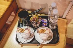 ein Tablett mit zwei Tellern Essen und Flaschen Wasser in der Unterkunft Hotel EPIDAVROS in Nafplio