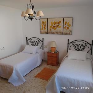 カディスにあるAtico Soleadoのベッドルーム1室(ベッド2台、ランプ付きテーブル付)