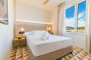 a bedroom with a large white bed and a window at Akquaaa Boutique Hotel in Calafell