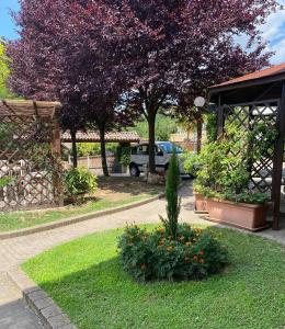 a garden with a tree and flowers in a yard at Bed And Breakfast Olimpia in San Salvatore Monferrato
