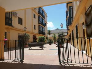 una puerta en un patio con un banco y edificios en Apartamento Tres Carabelas, AC, Wifi, Parking, en Sanlúcar de Barrameda