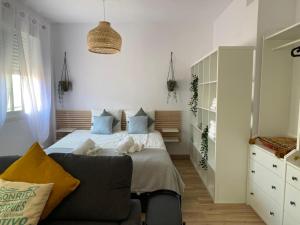 ein Schlafzimmer mit einem Bett und einem Sofa in der Unterkunft Loft en PLENO CENTRO in Sanlúcar de Barrameda