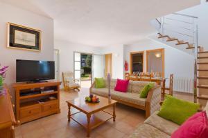 a living room with a couch and a tv at Villa Caballero by Villa Plus in Punta Prima