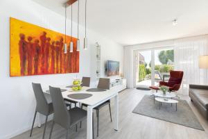 a living room with a dining room table and chairs at Hauptstrasse 26e PASSAT in Timmendorfer Strand