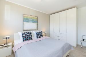 a white bedroom with a bed and a white cabinet at Hauptstrasse 26e PASSAT in Timmendorfer Strand