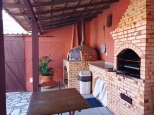 una cocina al aire libre con horno de pizza en un patio en CONFORT -PRAIA DE DUNAS - (Praia do Forte)-CABO FRIO - PRÓXIMO DAS PRINCIPAIS ATRAÇÕES, en Cabo Frío