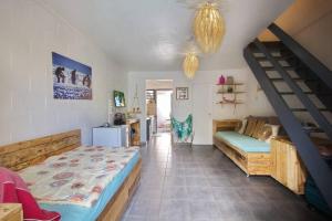 1 dormitorio con 1 cama y escalera. en Kaz Nomia - à 50m de la plage Roches Noires, en Saint-Gilles-les-Bains