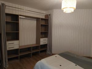 a bedroom with a bed and a closet with shelves at Appartement moderne dans village de charme in Salviac