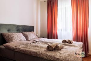 łóżko z dwoma ręcznikami i oknem w obiekcie Music House Apartment w mieście Tuzla