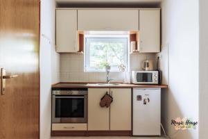 a small kitchen with a sink and a microwave at Music House Apartment in Tuzla