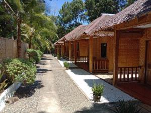 una fila de cabañas en un complejo con palmeras en Alona Pawikan, en Panglao