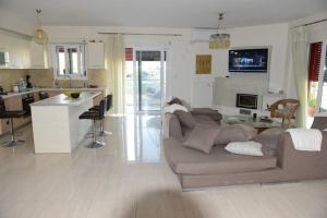 a living room with a couch and a kitchen at Ducky House in Preveza