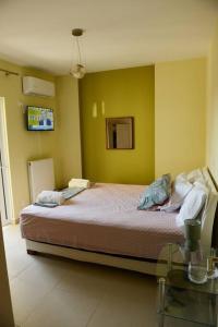 a bedroom with a large bed with yellow walls at Ducky House in Preveza
