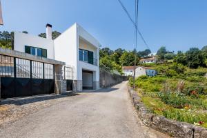 a white house on a hill with a driveway at Casa da Leira in Vila Nova de Cerveira