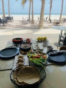 a table with plates of food on the beach at Beautiful Flat By The Beach Salalah in Salalah