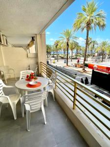 een balkon met een tafel en stoelen en een televisie bij APARTBEACH NOVELTY CLIMATIZADO y VISTAS PLAYA in Salou