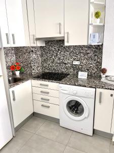 a white kitchen with a washing machine in it at APARTBEACH NOVELTY CLIMATIZADO y VISTAS PLAYA in Salou