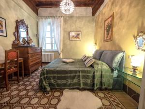 a bedroom with a bed and a table and a desk at LUXURY - Elegante appartamento nel cuore di Lucca in Lucca