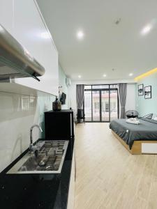 ein Schlafzimmer mit einem Bett und eine Küche mit einem Waschbecken in der Unterkunft MIDMOST C22 Apartment in Cần Thơ