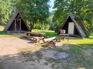 a tent with a picnic table and benches in a field at Annimatsi Camping in Otepää