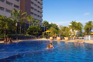 uma mulher numa piscina num hotel em Celebration Resort Olímpia by Hot Beach em Olímpia