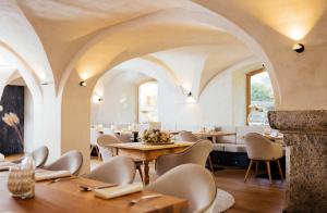 restauracja ze sklepionym sufitem, stołami i krzesłami w obiekcie Hotel Gasthof Hirschentenne w mieście Stams