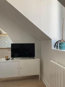 a flat screen tv sitting on a dresser in a living room at Studio neuf Pont-rousseau Rezé in Rezé