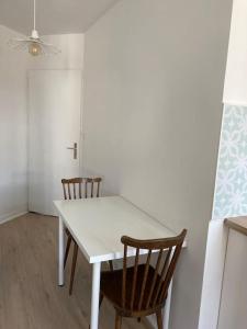 a white table and two chairs in a room at Studio neuf Pont-rousseau Rezé in Rezé