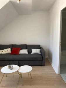 a living room with a couch and two tables at Studio neuf Pont-rousseau Rezé in Rezé
