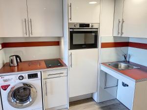 una pequeña cocina con lavadora y fregadero en Le Cannet Appart'S, en Le Cannet