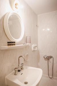 a white bathroom with a sink and a mirror at Hotel EPIDAVROS in Nafplio