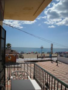 a person standing on a ledge overlooking a beach at Hostal Flor Blanco in Torremolinos