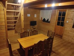 ein Esszimmer mit einem Holztisch und Stühlen in der Unterkunft Domki Letniskowe Kama 514 - 280 - 102 in Solina