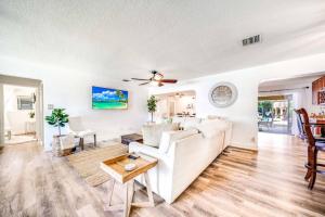 a living room with a white couch and a ceiling fan at Chique Pool and Tiki Resort in Pompano Beach