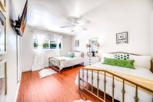 a bedroom with two beds and a ceiling fan at Chique Pool and Tiki Resort in Pompano Beach +59 photos