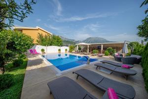 a swimming pool with lounge chairs and a house at Lux Villa Princess in Bar