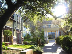 een huis met een veranda in een tuin bij Zomerlust Boutique Hotel in Paarl