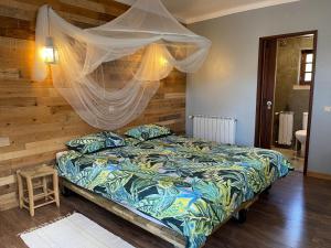 a bedroom with a bed with a mosquito net above it at Casa do Páteo in Aldeia do Meco