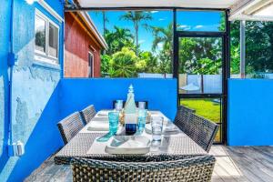 einen Tisch und Stühle auf der Terrasse eines Hauses in der Unterkunft Pool and Hot Tub Just 10 Close to All in Fort Lauderdale