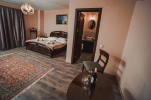 スレムスキ・カルロヴツィにあるVilla 1880のベッドルーム1室(ベッド1台、テーブル、椅子付)