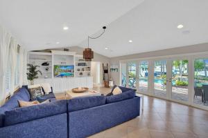 un soggiorno con un divano blu e un tavolo di Waterfront Pool Dream Vacation a Pompano Beach