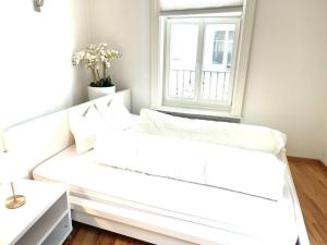 ein weißes Sofa in einem Zimmer mit Fenster in der Unterkunft Aufenthalt im Herzen von Luzern in Luzern