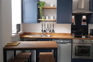 a kitchen with blue cabinets and a sink at Sea Reach Apartment, 2 minutes from beach and town in Newquay